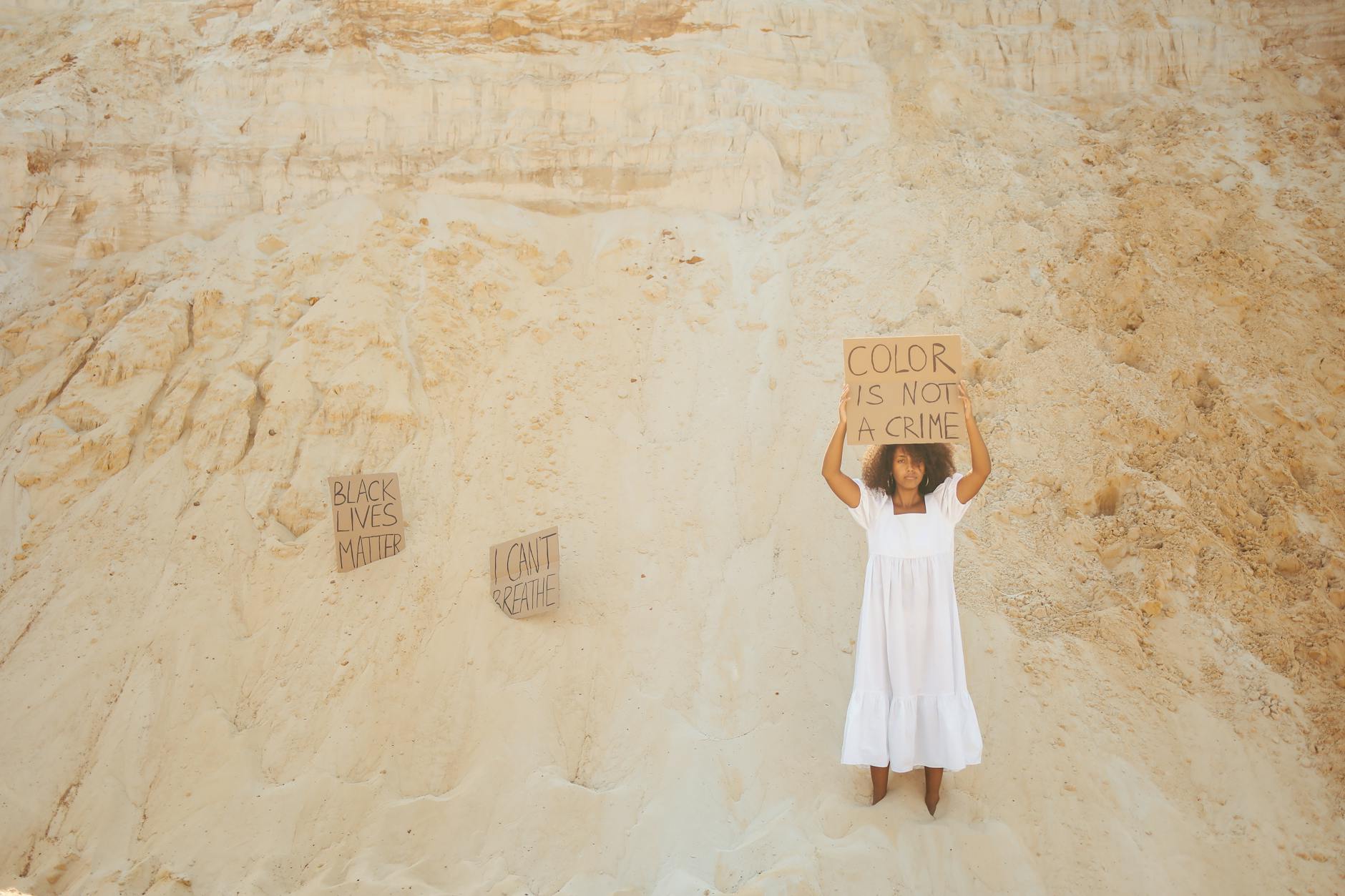 woman in white dress with anti racism sign